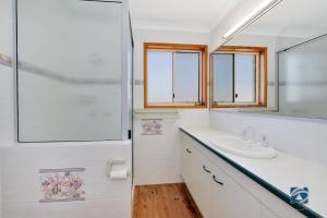 a bathroom with a sink and a mirror at 25 The Esplanade in Woodgate