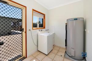 a bathroom with a washer and dryer next to a window at 25 The Esplanade in Woodgate