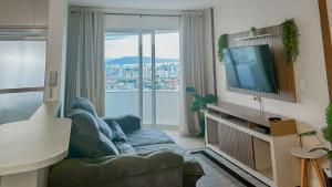 a living room with a couch and a flat screen tv at Condomínio próximo a ponte Hercílio Luz in Florianópolis