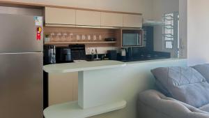a kitchen with a counter and a chair and a refrigerator at Condomínio próximo a ponte Hercílio Luz in Florianópolis