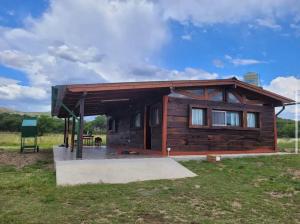 a small wooden cabin with a bench in a field at Cabaña Elun in Panaholma