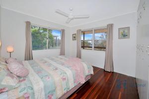 a bedroom with a bed and a window at 103 The Esplanade in Woodgate