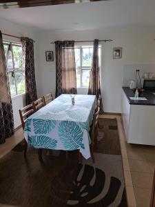 a dining room with a table and a kitchen at Sekoula Home in Suva