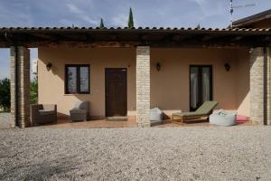 een patio van een huis met een bank en stoelen bij PinetoAlba in Scerne