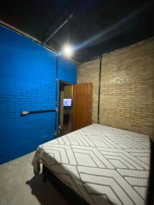 a bedroom with a bed in a blue room at Fabulosa Casa de tijolinho in Arapiraca +15 photos