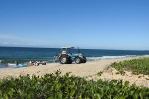 a tractor parked on a beach near the ocean at 73 The Esplanade in Woodgate +2 photos