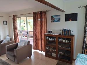 a living room with a chair and a book shelf at Sekoula Home in Suva +8 photos