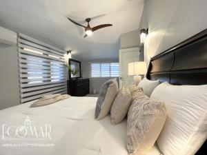 a bedroom with a large white bed with a ceiling fan at EcoMar Rentals: Villa in Cabo Rojo +54 photos