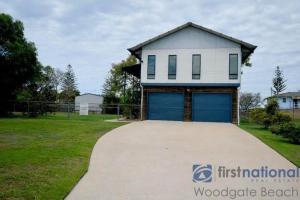a house with a blue garage on a driveway at 62 First Avenue in Woodgate