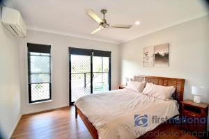 a bedroom with a bed and a ceiling fan at 62 First Avenue in Woodgate