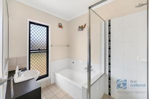 a bathroom with a bath tub and a sink at 62 First Avenue in Woodgate +20 photos
