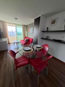 een woonkamer met een tafel en rode stoelen bij Flat à beira mar, charmoso e aconchegante in João Pessoa