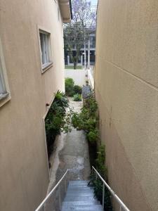 een steegje tussen twee gebouwen met trappen en planten bij Suite/loft Jardim Botanico in Curitiba