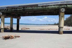 a pier on a beach with the ocean in the background at 198 The Esplanade in Woodgate