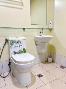 a bathroom with a toilet and a sink at Horizons 101 in Cebu City