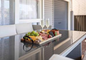 a tray of food on a table with wine glasses at Coastal Palms - Family & Pet-Friendly Beachside Haven in Lake Illawarra +18 photos