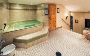 a bathroom with a tub with a toilet and a sink at Wellnesshotel Engadin in Samnaun