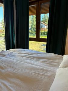 una camera da letto con un letto bianco e una finestra di Magnet Lux Zlatibor 
