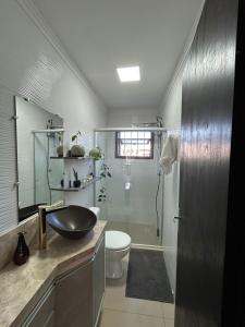 a bathroom with a sink and a toilet and a shower at Casa perto do mar in Capão da Canoa +8 photos