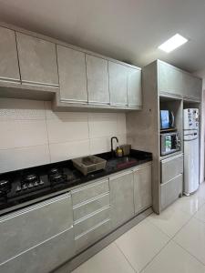 a kitchen with stainless steel cabinets and a refrigerator at Casa perto do mar in Capão da Canoa