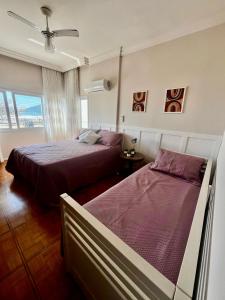 ein Schlafzimmer mit zwei Betten und einem Fenster in der Unterkunft Fantástico apartamento Frente ao mar em Balneário Camboriú in Balneário Camboriú