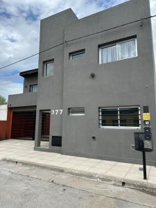 een grijs gebouw met een parkeermeter ervoor bij Modern apartment in Azul in Azul