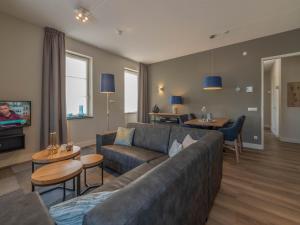 a living room with a couch and a tv at SeaLuxe Suite 27D in Colijnsplaat