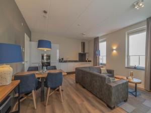 a living room with a couch and a table at SeaLuxe Suite 27D in Colijnsplaat
