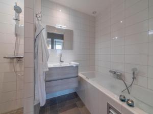 a white bathroom with a tub and a sink and a bath tub at SeaLuxe Suite 27D in Colijnsplaat +11 photos