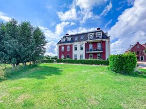 a large red and white house with a yard at SeaLuxe Suite 27D in Colijnsplaat