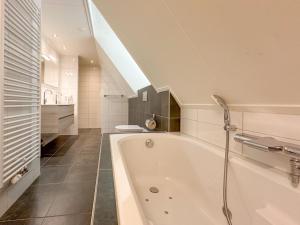a bathroom with a bath tub and a staircase at Happy Beach 48 in Colijnsplaat +43 photos