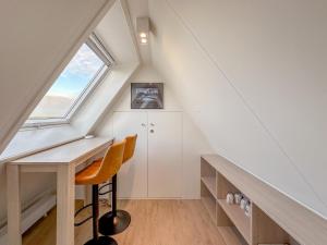 an attic room with a desk and a window at Happy Beach 48 in Colijnsplaat