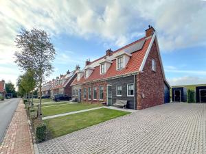 a large brick house with a red roof on a street at Happy Beach 48 in Colijnsplaat