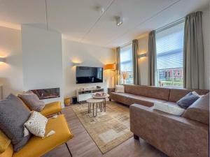 a living room with a couch and a tv at Happy Beach 50 in Colijnsplaat
