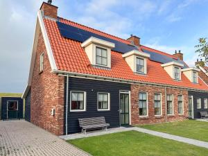 a house with an orange roof and a bench at Happy Beach 50 in Colijnsplaat