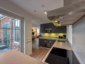 a kitchen with black cabinets and a large window at Happy Beach 50 in Colijnsplaat
