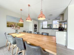 Una cocina y un comedor con una gran mesa y sillas de madera. en Coast and Calm 63, en Colijnsplaat
