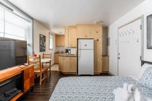 a bedroom with a bed and a kitchen with a refrigerator at Suitestay Apartments Hotel in Ottawa
