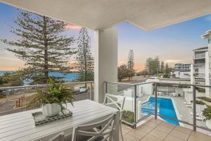 een balkon met een tafel en uitzicht op de oceaan bij Dwell at 38, Oceanfront Apartment in Bargara