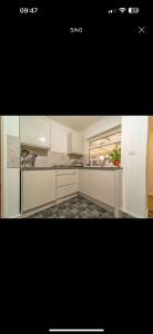 Una cocina con gabinetes blancos y encimera. en Newport by M4, en Newport 5 fotos más