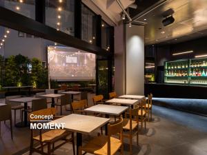 Un restaurante con mesas y sillas y una pantalla grande. en sequence SUIDOBASHI - Tokyo, en Tokio