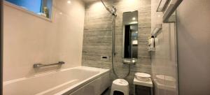 een witte badkamer met een bad en een toilet bij Kamakura Koshigoe Ekimae B in Kamakura +46 foto's
