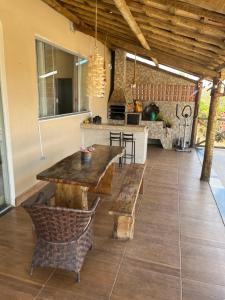 Un patio con mesa y sillas de madera y una cocina. en Ranchinho Serra do Cipó, en Jaboticatubas 9 fotos más