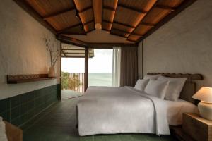 een slaapkamer met een wit bed en een groot raam bij Paradise Retreat Hon Son in Lai Sơn