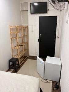 a room with a bed and a television and a door at pousada ranchinho sorocaba in Sorocaba