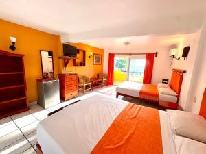 a hotel room with two beds and a kitchen at BEACH HOTEL INES en Zicatela in Brisas de Zicatela