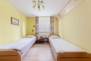 due letti in una stanza con pareti gialle di Apartma Franko a Cerklje na Gorenjskem