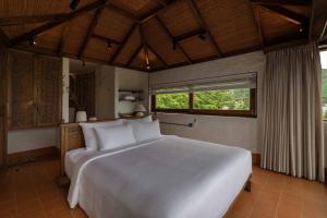 een slaapkamer met een groot wit bed en een raam bij Paradise Retreat Hon Son in Lai Sơn