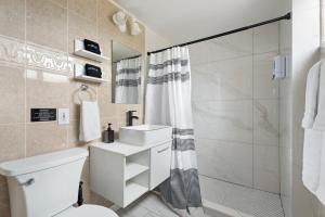 a bathroom with a white toilet and a shower at Near Safari & Beach - Backyard Games - AC - Pet OK in Escondido +36 photos