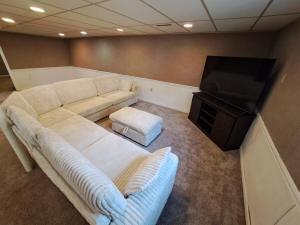 a living room with a couch and a flat screen tv at Location! Large Home, Country Views, Entertainment in Dubuque